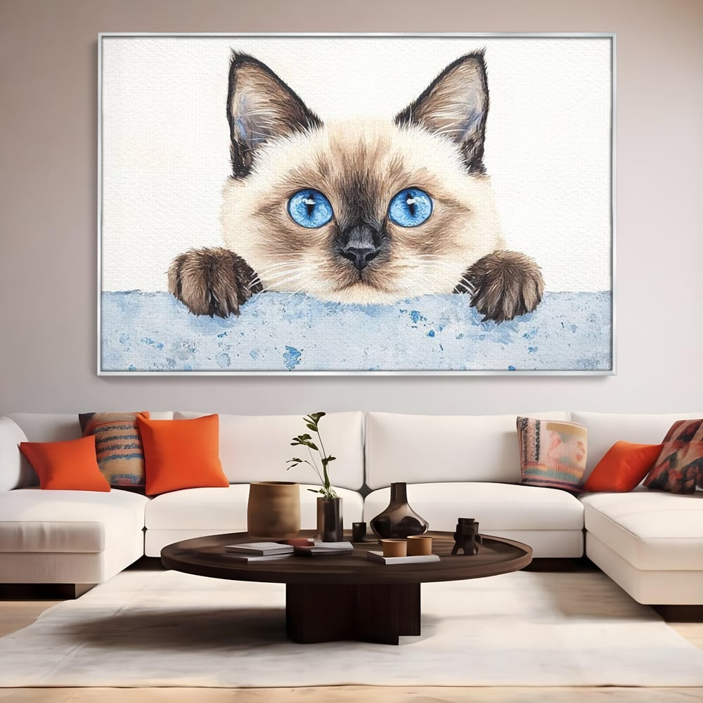 Tablou canvas cu tablou canvas cu pisica siameza si ochi albastrii, in rama de aluminiu argintiu, pe perete intr-un living